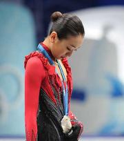 ２位の表彰台で、銀メダルを左手で触れながら寂しそうに見つめる浅田

