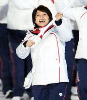 日本選手団の旗手をつとめ笑顔で日の丸を振る岡崎朋美（撮影・上田博志）
