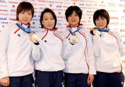 銀メダルを手に笑顔を見せる左から小平、橋本団長、田畑、穂積